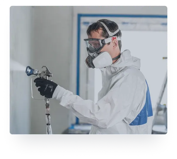 Certified applicator in protective gear spraying FlameOFF fire retardant coating with an airless sprayer
